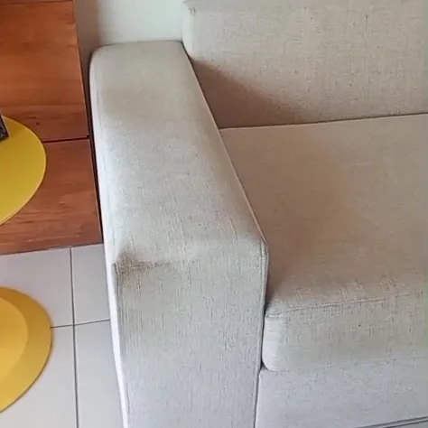 Sofá claro antes da higienização, numa sala de piso branco