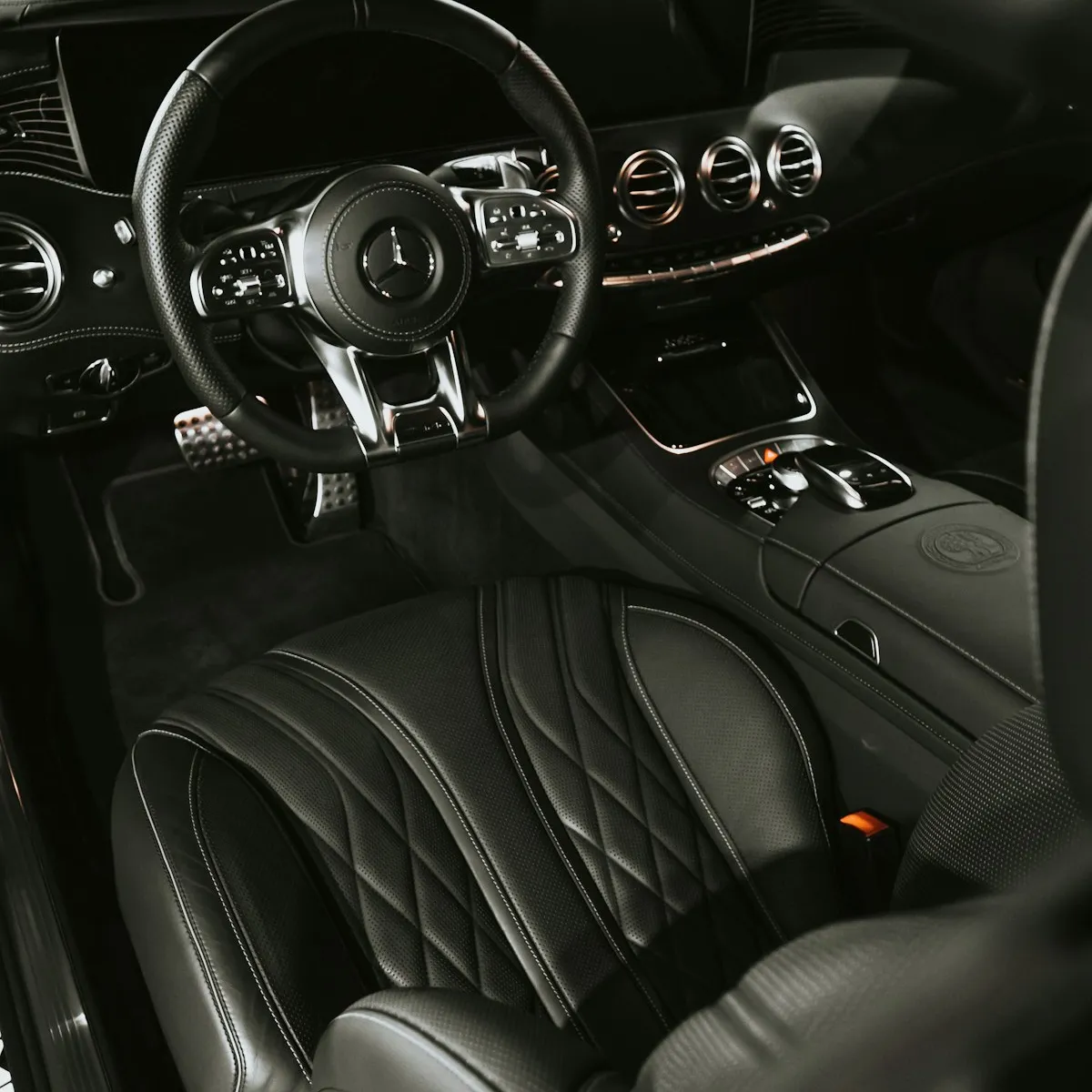 Interior de um carro, com volante e bancos de couro